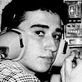 Young man using vintage radio with headphones.