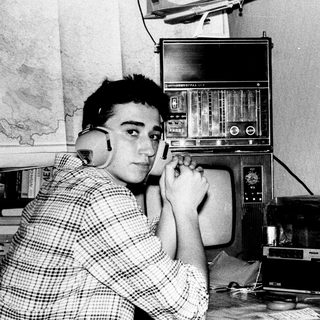 Young man using vintage radio with headphones.