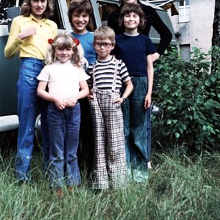 Family posing together outside vintage van.