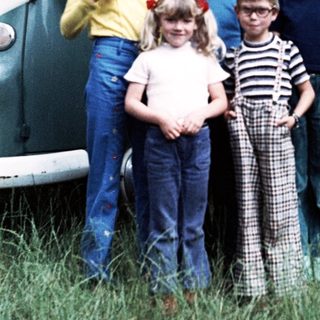 Family posing together outside vintage van.