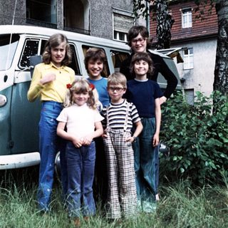 Family posing together outside vintage van.