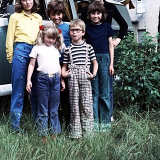 Family posing outdoors near vintage van.