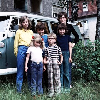 Family posing outdoors near vintage van.