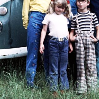 Family posing outdoors near vintage van.