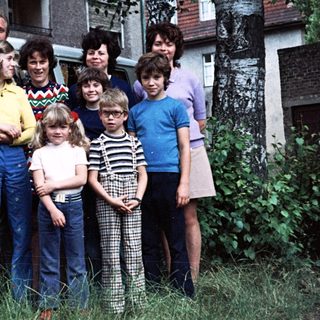 Family group photo with camper van, mid-1970s to 1980s.