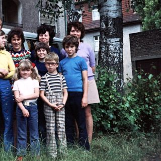 Family group photo with camper van, mid-1970s to 1980s.