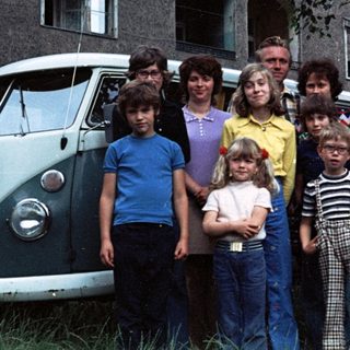 Family group photo in front of a van.