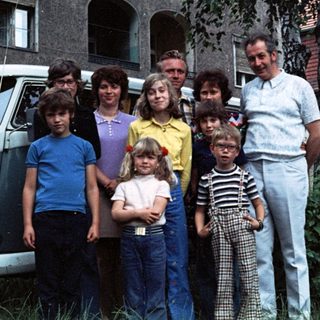 Family group photo in front of a van.