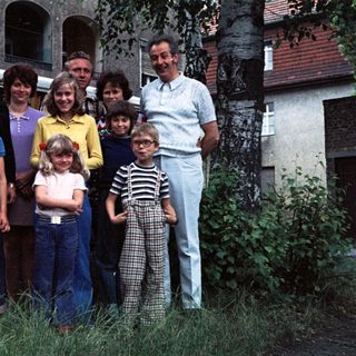 Family posing together outside a Volkswagen van.