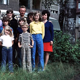 Family posing with vintage Volkswagen van.