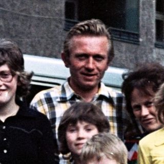 Family posing with vintage Volkswagen van.