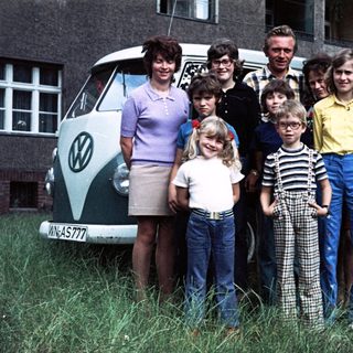Family posing with vintage Volkswagen van.