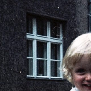 Two people, likely mother and child, smiling outdoors.