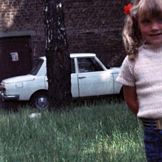 Two children playing in grassy backyard.