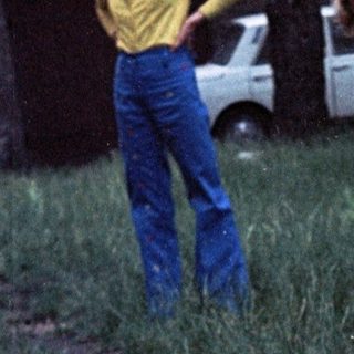 Young child playing outdoors in grassy yard.