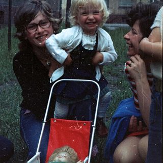 Happy family enjoying rain with child in stroller.