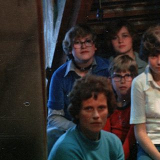 Family group photo in dimly lit indoor setting.