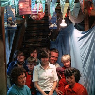Family group posing indoors during festive celebration.