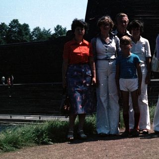 Group of people posing outdoors near modern building.
