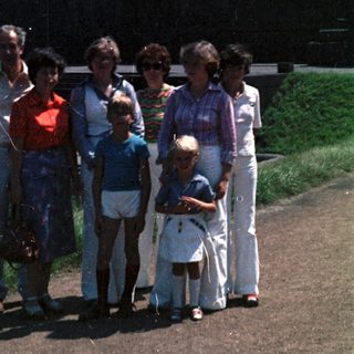 Family group photo near waterfront in outdoor setting.