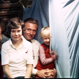 Family group posing indoors with festive paper decorations.