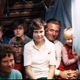 Family group posing indoors with festive paper decorations.