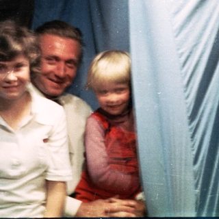 Family group posing indoors with festive paper lanterns.