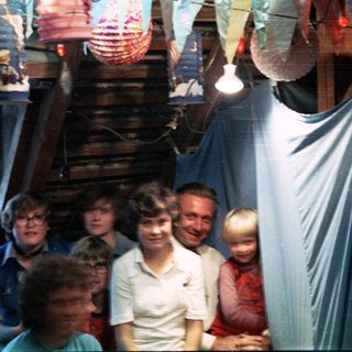 Family group posing indoors with festive paper lanterns.