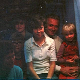 Family group posing indoors with dim lighting.