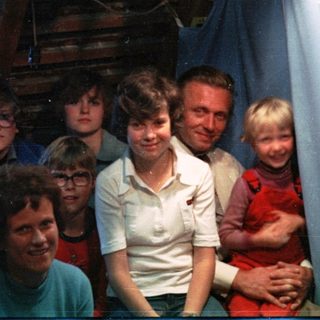 Family group photo in a rustic indoor setting.