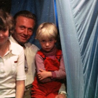 Family group in festive indoor setting with holiday decorations.