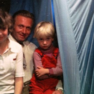 Family group in festive indoor setting with holiday decorations.