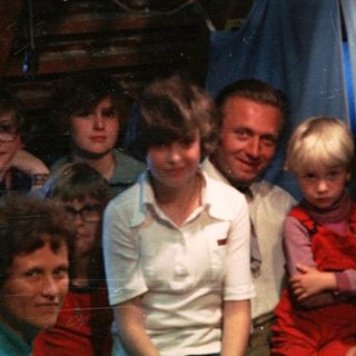 Family group in festive indoor setting with holiday decorations.