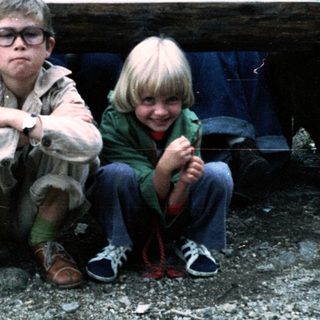 Family group photo outdoors on wooden bench.