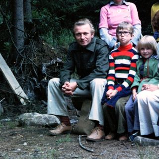 Family group photo outdoors in forested area.