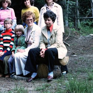 Family group photo outdoors in forested area.