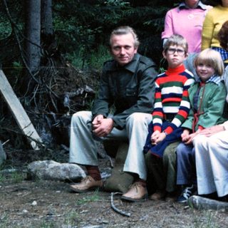 Family group photo in forested outdoor setting.