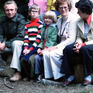 Family group photo in forested outdoor setting.