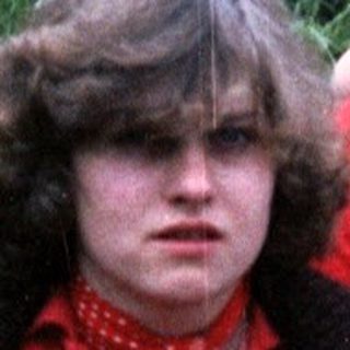 Three people sitting outdoors in 1970s-style clothing.