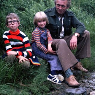 Family posing outdoors on rocky path.