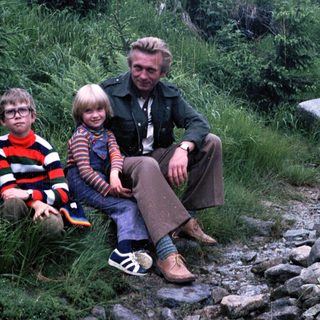 Family posing outdoors on rocky path.