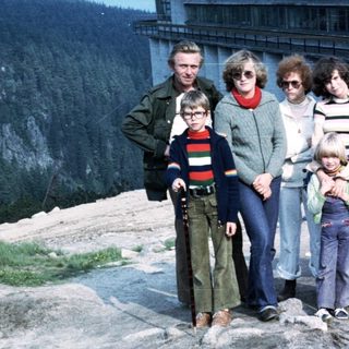 Family group posing outdoors near mountain resort.