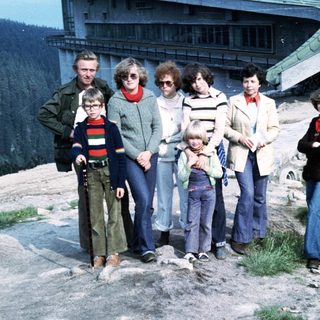Family group posing outdoors near mountain resort.