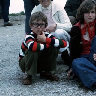 Family group posing outdoors in 1980s-style clothing.
