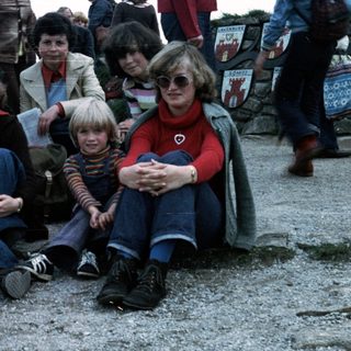 Family group posing outdoors in 1980s-style clothing.