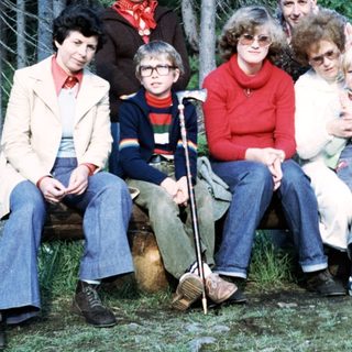 Family group photo outdoors in forest setting.