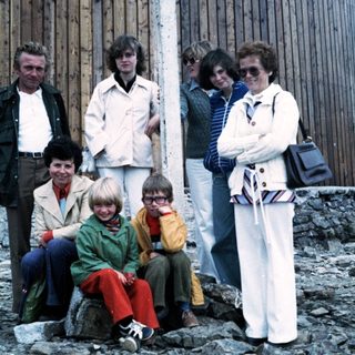 Family group posing outdoors near rocky terrain.