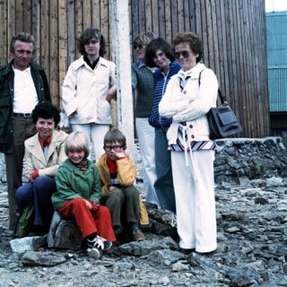 Family group posing outdoors near rocky terrain.