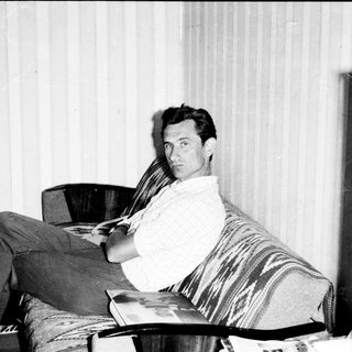 Man reading newspaper in relaxed indoor setting.