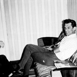 Man relaxing in armchair with scarf, reading.